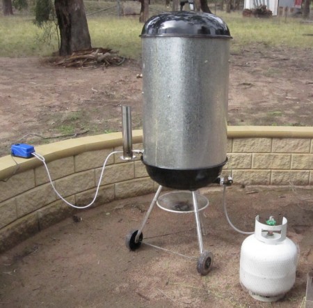 FrankenSmoker. A Converted Webber BBQ as a smoking vessel. The UFO Cold Smoke Generator is on the left. A small gas burner has been install at the bottom fed by a gas on the right.