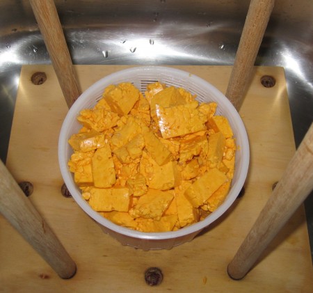 Curds chopped and salted ready to be pressed - 6 hours into the process now. The curds are strongly orange now.